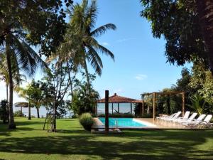 un resort con piscina e palme di Vista Linda Cumuruxatiba a Cumuruxatiba