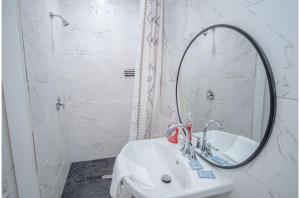 bagno con lavandino bianco e specchio di Adorable Guesthouse So Close to Amazing Downtown a San Antonio