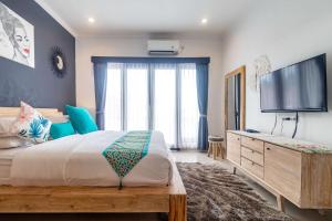 ein Schlafzimmer mit großem Bett und Flachbildfernseher in der Unterkunft Villa Alhena in Canggu + 37 Fotos
