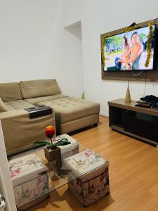 a living room with a couch and a flat screen tv at Rua Bolivar, nº 154, Copacabana - Apartamento para Temporada, perto da Praia in Rio de Janeiro