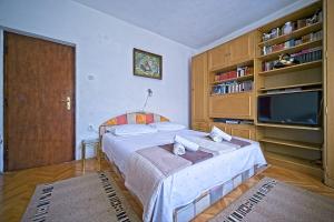 una camera con letto e TV a schermo piatto di Apartment Pavo - 80 m from beach a Postira (Postire)