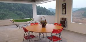 una camera con tavolo, sedie e amaca di Mountain Breath Retreat - Am Nui Tho a Yen Bai