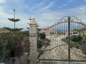 a gate to a garden with flowers and plants at La valle degli dei in Eraclea Minoa