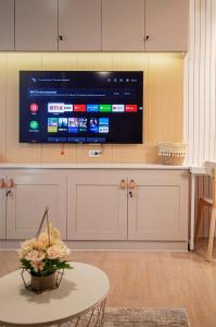 a living room with a large tv on a wall at Cozy and Classy Studio Across Airport Terminal 3 in Manila