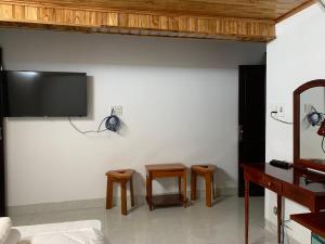 a living room with two chairs and a tv on the wall at Phố Seoul Homestay And Spa in Hoi An