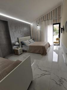 a bedroom with two beds and a marble floor at La valle degli dei in Eraclea Minoa