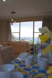 una mesa con tazones y platos con vistas al océano en Burnie BNB With Ocean Views, en Burnie