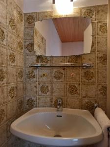 a bathroom with a sink and a mirror at Appartements direkt am See in Grundlsee +37 photos