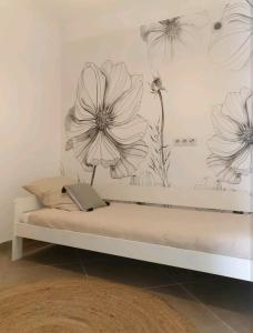 - une chambre avec un lit orné d'une fresque murale représentant des fleurs dans l'établissement Pianotolinca, à Moltifao