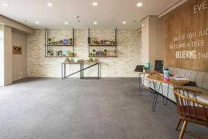 a waiting room with tables and a brick wall at Stunning urban view at Vista Heights Legarda in Manila