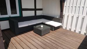 eine Terrasse mit einer Bank und einem Tisch auf einer Terrasse in der Unterkunft Ferienwohnung zur Silbertanne in Ilsenburg