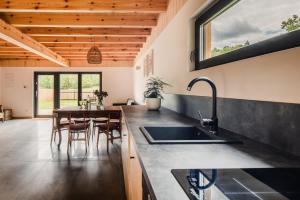 a kitchen with a sink and a table with chairs at Na łące u pradziadka in Wiele