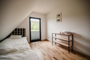 1 dormitorio con 1 cama, mesita de noche y ventana en Na łące u pradziadka, en Wiele