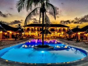 a resort with a palm tree in front of a building at Paje Blu Boutique Hotel in Paje