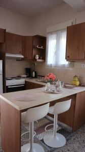a kitchen with a table and two stools in it at Artemis House in Agios Nikolaos
