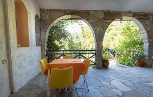 a table and chairs on a patio with an archway at Christeluda in Neos Marmaras