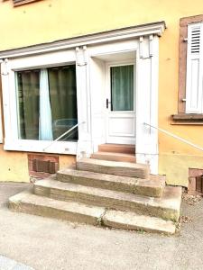 drzwi wejściowe domu ze schodami z przodu w obiekcie L'Ancienne Epicerie à Beblenheim w mieście Beblenheim