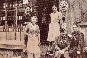 an old photo of a family posing for a picture at L'Ancienne Epicerie à Beblenheim in Beblenheim