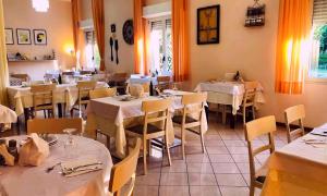 Hotel Villa Gioiosa في ريميني: مطعم به طاولات وكراسي به مفارش بيضاء