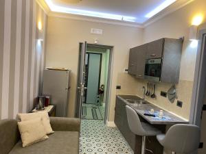 a small kitchen with a sink and a refrigerator at The world suite in Tropea