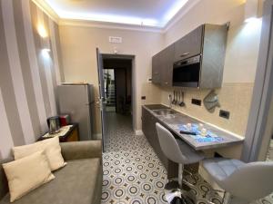 a kitchen with a sink and a couch in a room at The world suite in Tropea