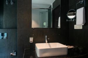 uma casa de banho com um lavatório branco e um espelho. em Ramada by Wyndham Gangtok Hotel & Casino Golden em Gangtok