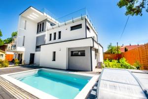 a villa with a swimming pool in front of a house at MyFlat Villa Nuvola in Siófok