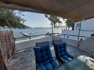 two chairs and a table on the back of a boat at Vitamin Sea house in Panayía