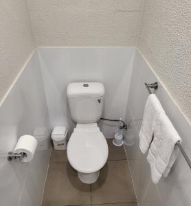 een kleine badkamer met een wit toilet en handdoeken bij Central Motel Mooloolaba in Mooloolaba