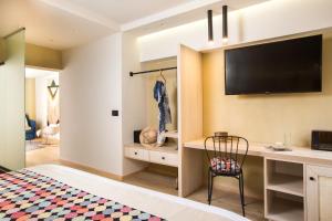 a bedroom with a desk and a television on a wall at C Suites in Rethymno Town