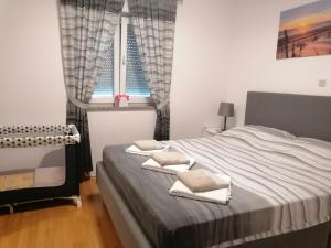 ein Schlafzimmer mit einem Bett mit zwei Kissen und einem Fenster in der Unterkunft Apartment Sunčica in Pula