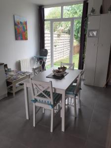 una mesa blanca y sillas en una cocina con ventana en Le Clos Doux, en Céaux