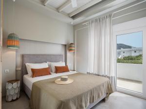 a bedroom with a bed and a large window at Anthos in Frangokastello