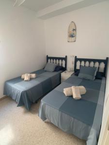 two beds with towels on them in a room at Motril - Poniente Beach in Motril