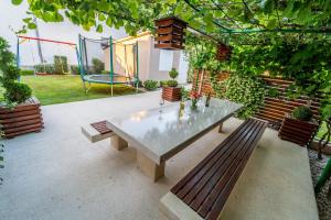 een patio met een tafel, banken en een schommel bij Apartment Sunčica in Pula