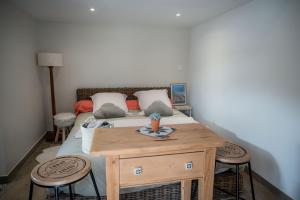 Schlafzimmer mit einem Bett und einem Holztisch in der Unterkunft Chambre Folle Avoine in Brié-et-Angonnes