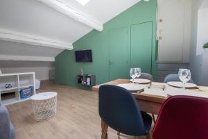 a room with a table and chairs and a television at Le Chapeau Rouge au coeur du centre historique in Avignon