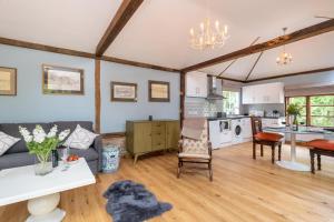 a living room with a couch and a kitchen at The Cart Lodge - Aldeburgh Coastal Cottages in Wickham Market