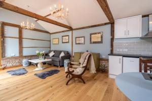 a kitchen and living room with a couch and a table at The Cart Lodge - Aldeburgh Coastal Cottages in Wickham Market