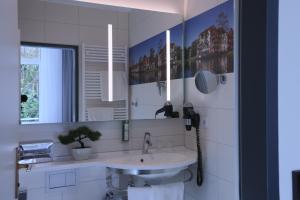 a bathroom with a sink and a mirror at LIHO - einfach Lübeck in Lübeck