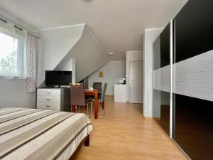 a bedroom with a bed and a desk and a table at Willa Bursztyn in Dębki