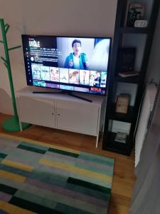 a flat screen tv sitting on a stand in a living room at Studio cosy aux portes de Bordeaux et Saint Emilion in Yvrac