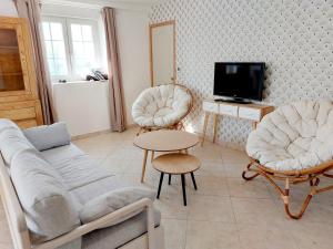 salon z kanapą, 2 krzesłami i telewizorem w obiekcie Le Rondot - Maison de campagne proche Mont-Saint-Michel 12km w mieście Précey