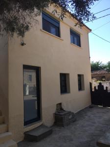 a house with two windows and a grill in front of it at Lemnian house in Portiano in Pedhinón