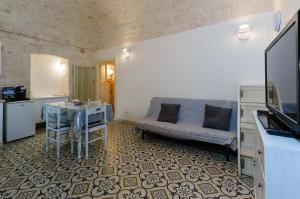 una camera con divano e tavolo in cucina di Casa Maristella a Cisternino