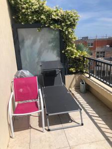 czerwone krzesło na balkonie w obiekcie Appartement a proximité du centre et de la Plage a Meze w mieście Mèze