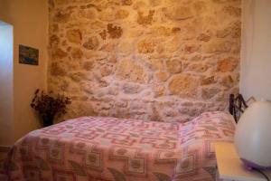 a bedroom with a bed and a stone wall at Michael Apartment in Áyios Andréas Messinias