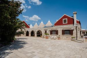 a large brick building with a red roof at Trulli D'autore in Martina Franca