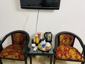 Deux chaises assises à côté d'une table avec un plateau de nourriture dans l'établissement THẢO AN 2 HOTEL Huế, à Thôn Lại Thê