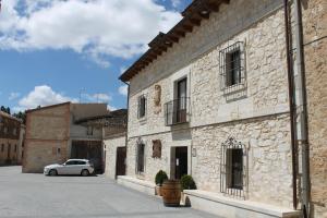 a white car parked in front of a building at Hotel Rural Restaurante Las Baronas in Santa Cruz de la Salceda